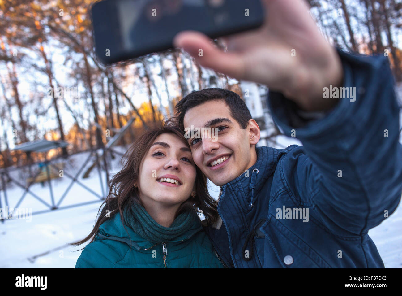 Happy young couple par selfies smart phone en hiver Banque D'Images