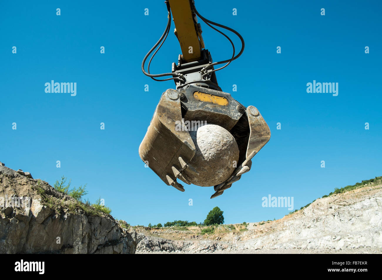Low angle view of picking griffe pelle rock sphère contre ciel bleu clair Banque D'Images