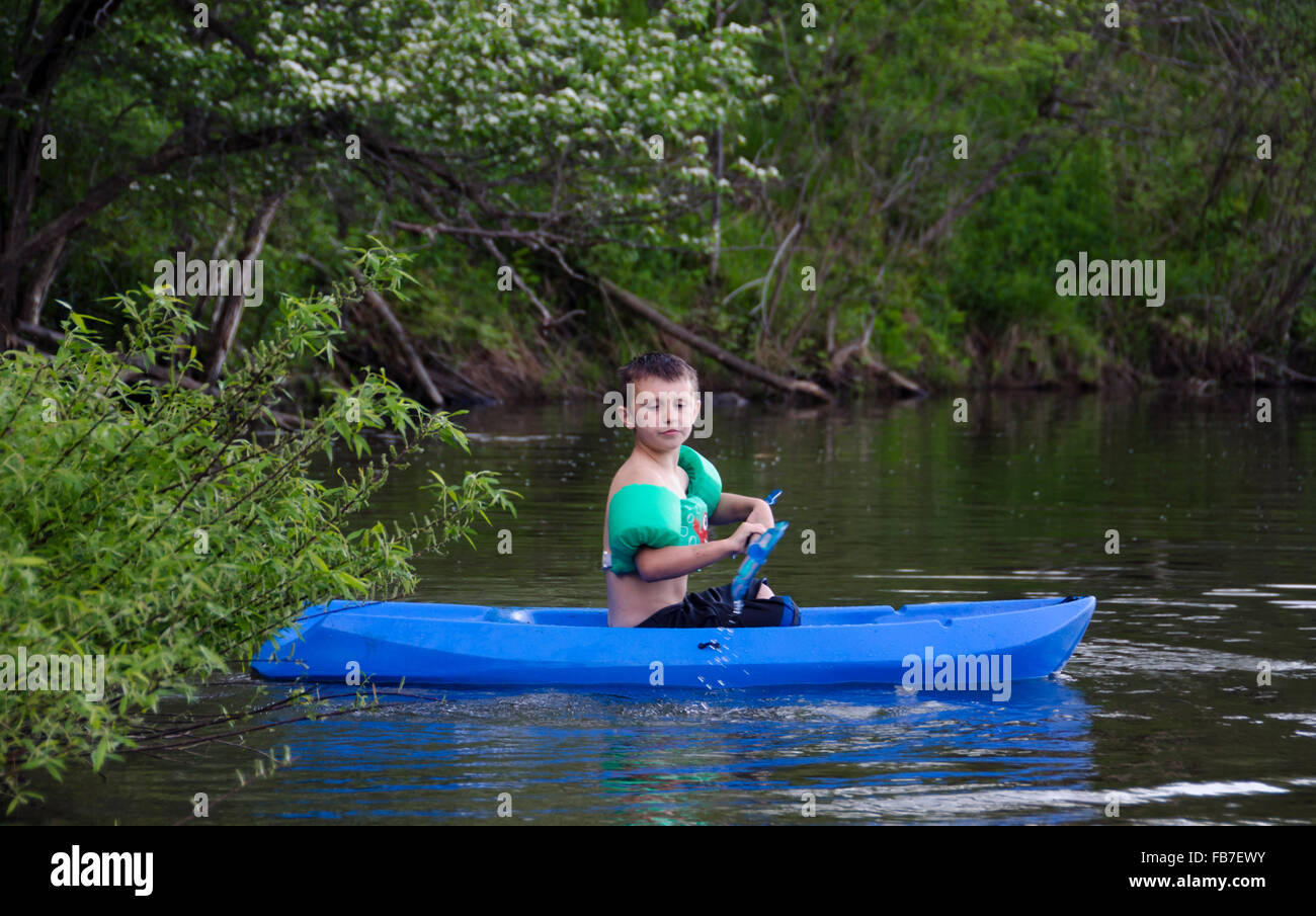 Jeune garçon en kayak sur l'étang ou lac en été Banque D'Images
