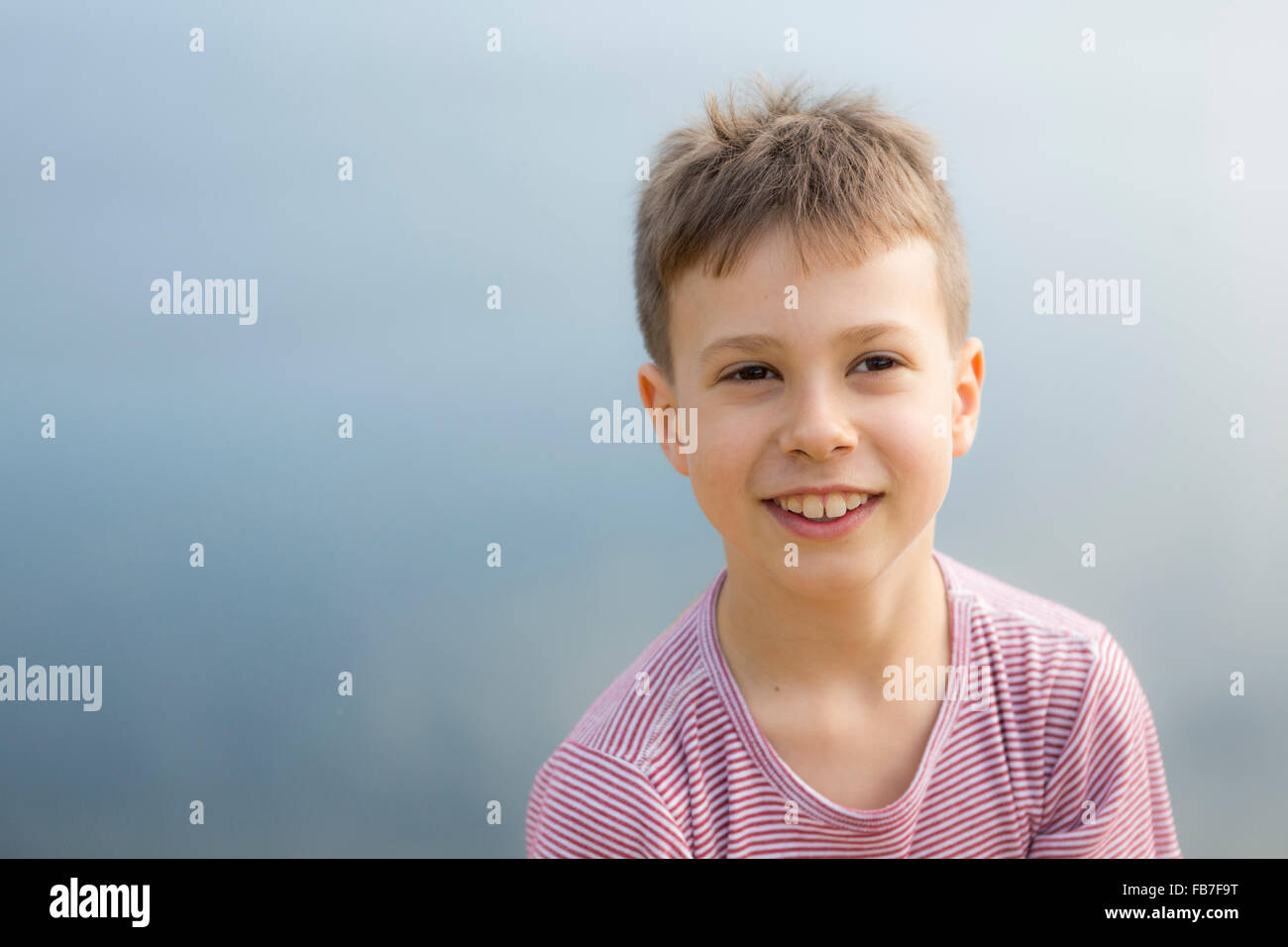 Alors que boy smiling réfléchie à la voiture à l'extérieur Banque D'Images