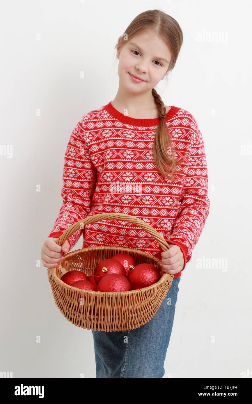 Smiley kid portant beau chandail rouge et holding Christmas decoration Banque D'Images