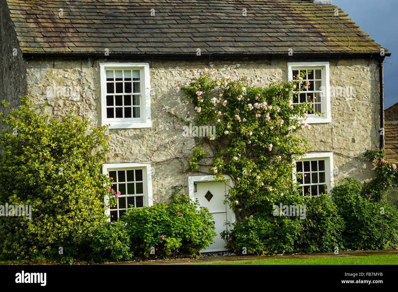 Belle maison de village avec rosiers grimpants, Yorkshire, Angleterre Banque D'Images