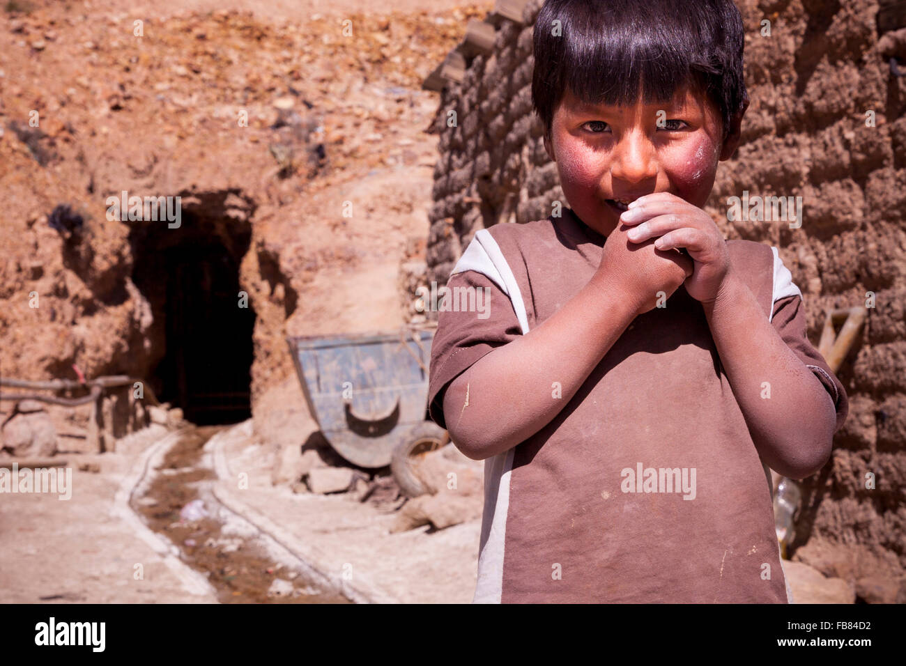 Le fils de mineur à l'entrée de la famille haute mine personnelle sur le flanc du Cerro Rico, Potosí, Bolivie. Banque D'Images