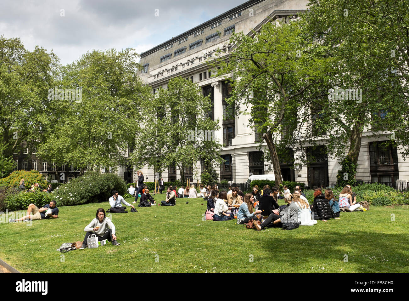 Aux personnes bénéficiant d'une belle après-midi ensoleillée à Bloomsbury Square Garden, London, UK Banque D'Images