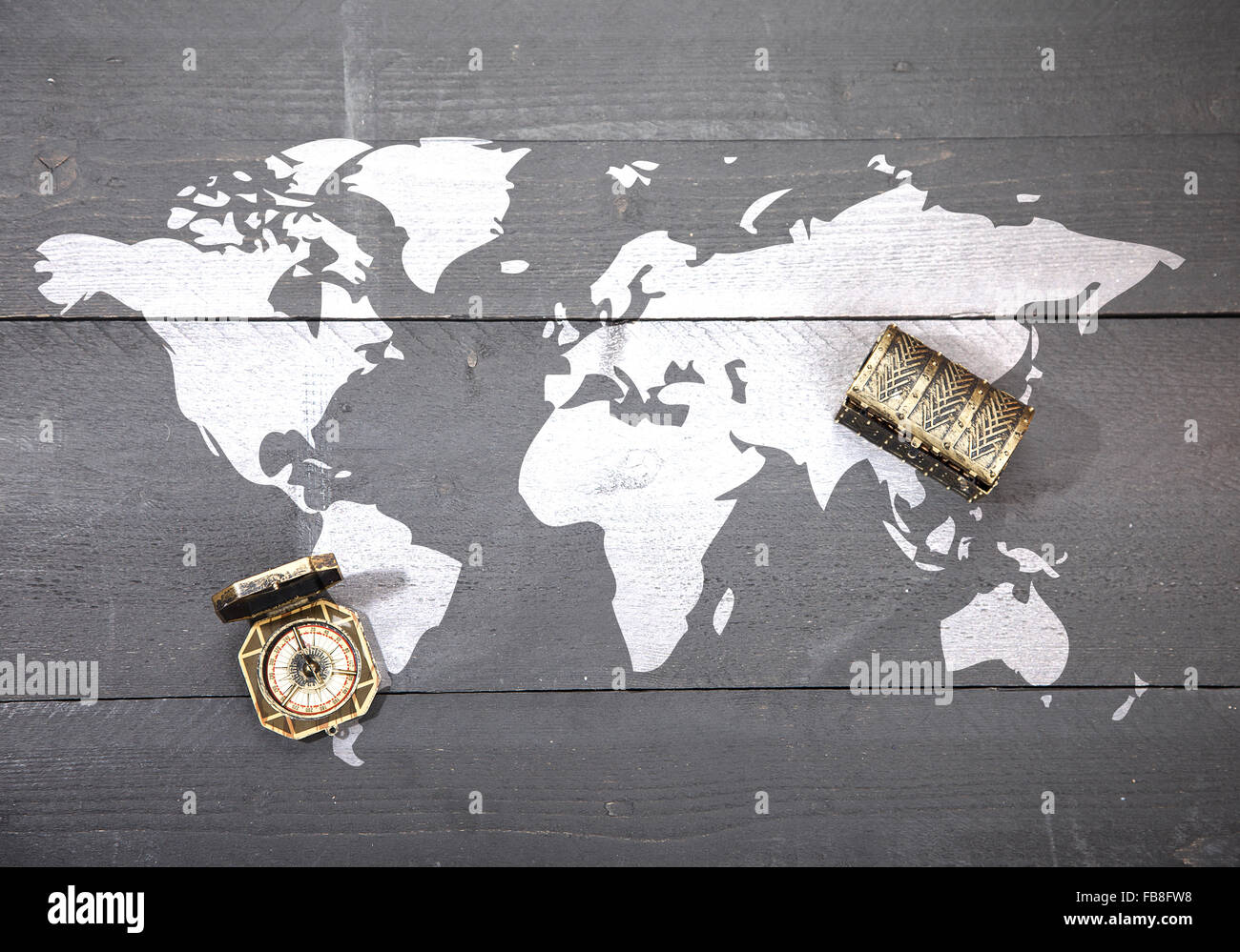 Carte du monde avec boussole et trésor noir foncé sur fond de bois Banque D'Images