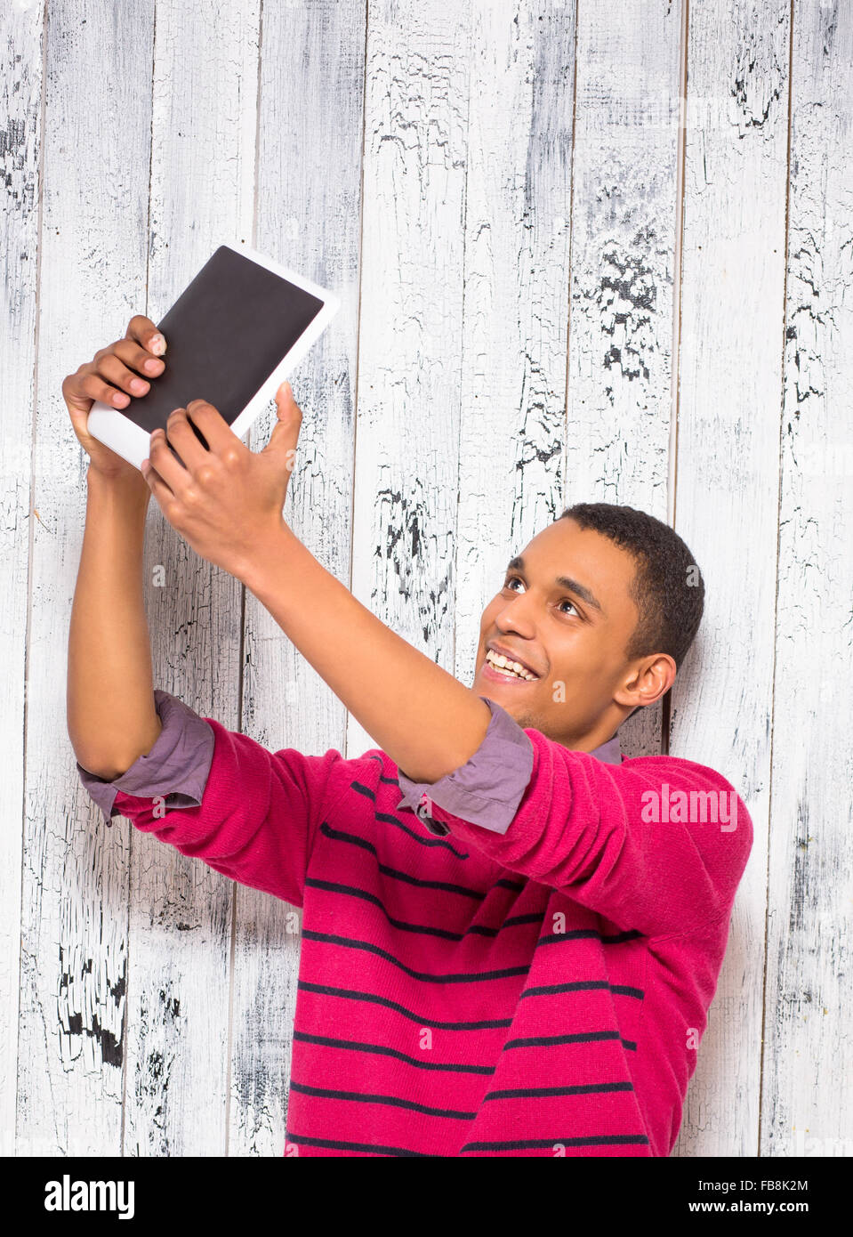 Beau jeune homme faisant autoportraits en studio Banque D'Images