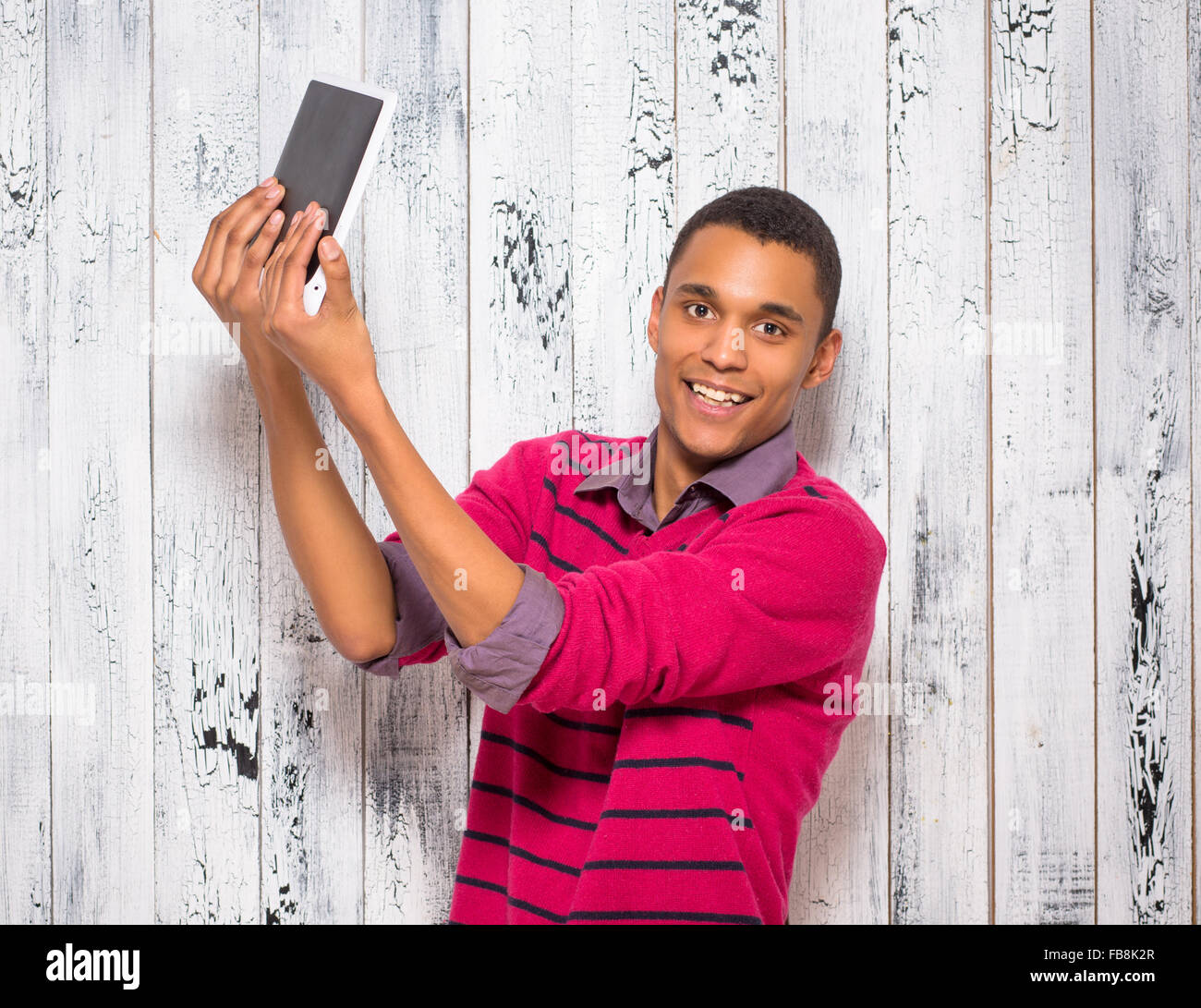 Beau jeune homme faisant autoportraits en studio Banque D'Images