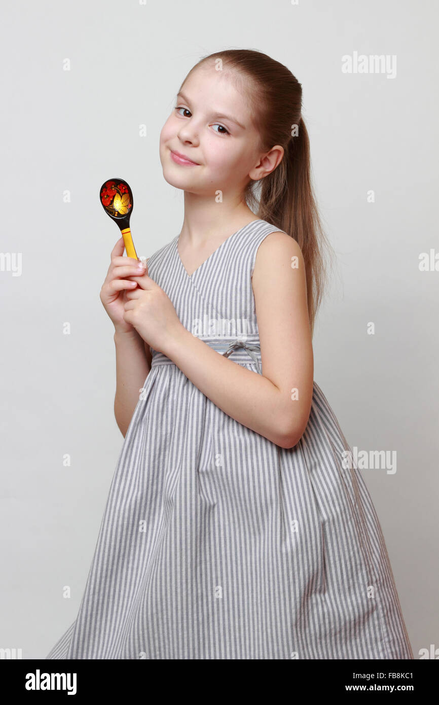 Belle petite fille européenne holding spoon Art style Hohloma en russe Banque D'Images