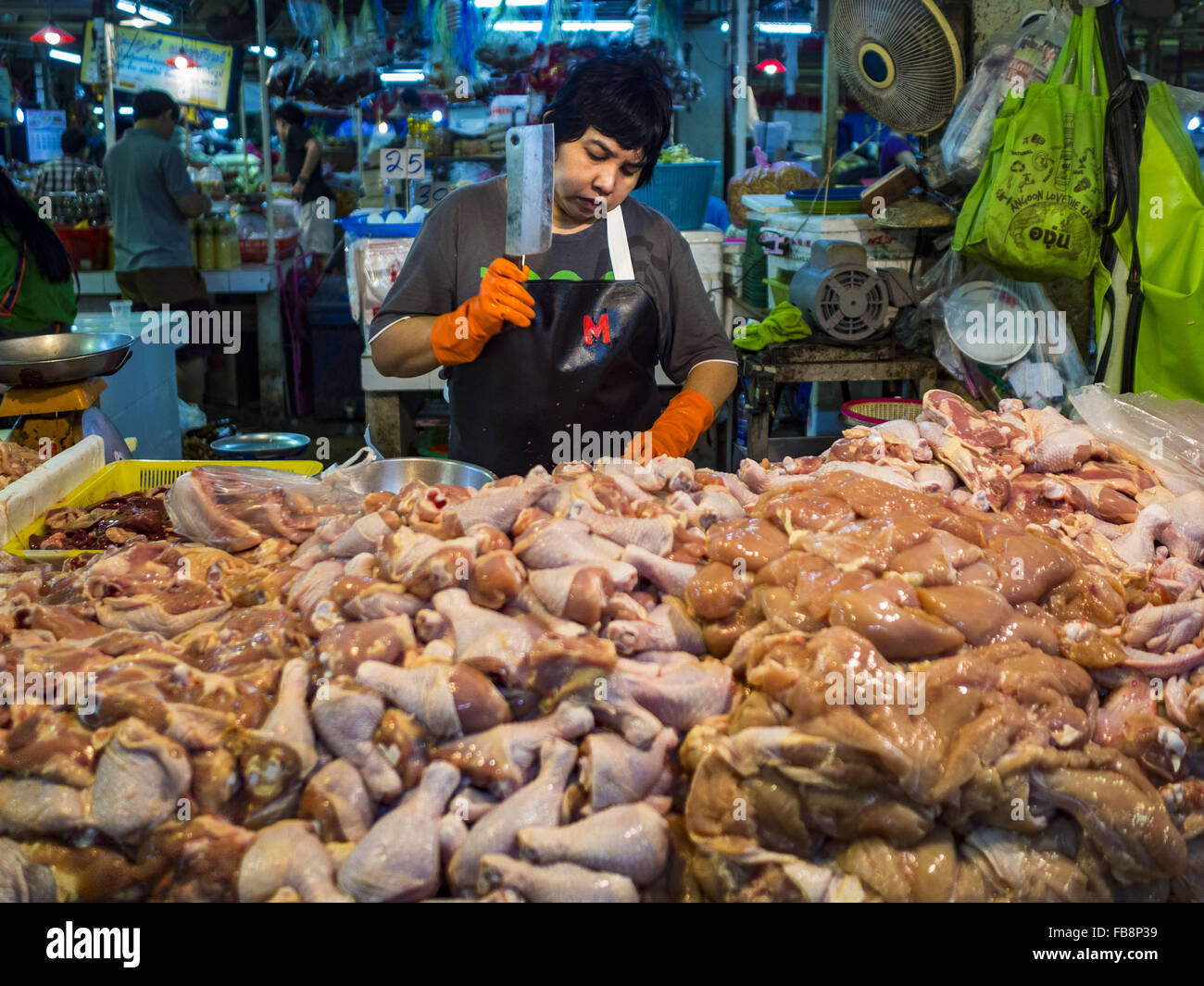 Bangkok, Thaïlande. 12 Jan, 2016. Un vendeur de coupe le poulet dans la section de la volaille de Khlong Toey Market à Bangkok. Le Ministère thaïlandais de la santé publique a chargé les organismes gouvernementaux pour rechercher tout signe la grippe aviaire pendant la saison d'hiver, et a avisé la population pour éviter tout contact avec les oiseaux qui apparaissent maladifs. Les dernières données de l'Organisation mondiale de la santé ont montré la transmission continue de la grippe aviaire dans plusieurs pays, tant dans les personnes et les oiseaux. La grippe aviaire est endémique en Chine, au Vietnam et en Indonésie, qui sont tous d'importants partenaires commerciaux de la Thaïlande. Credit : ZUMA Press, Inc./Alamy Live News Banque D'Images