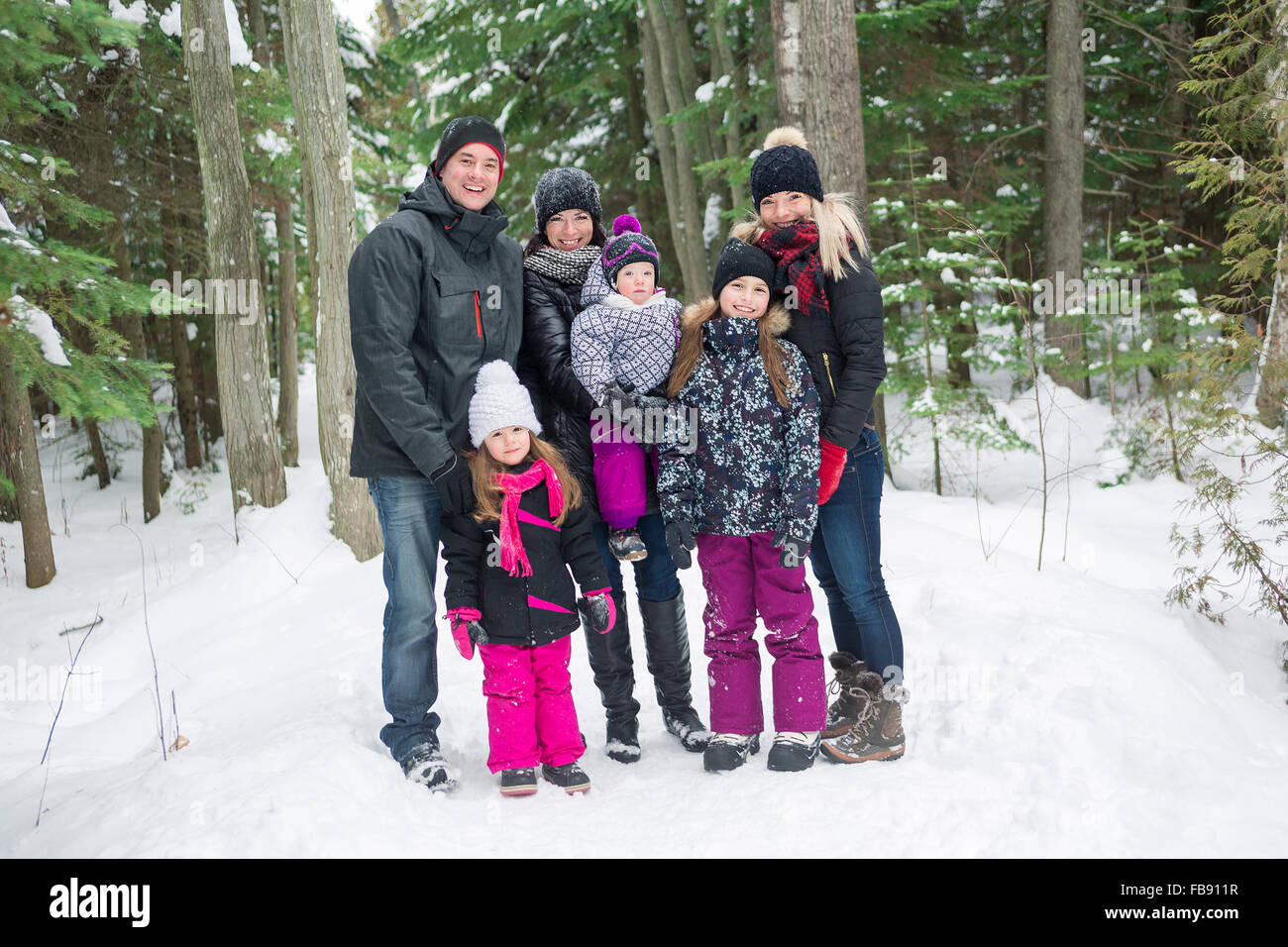 Heureux balades familiales et en jouant avec la neige en forêt d'hiver Banque D'Images