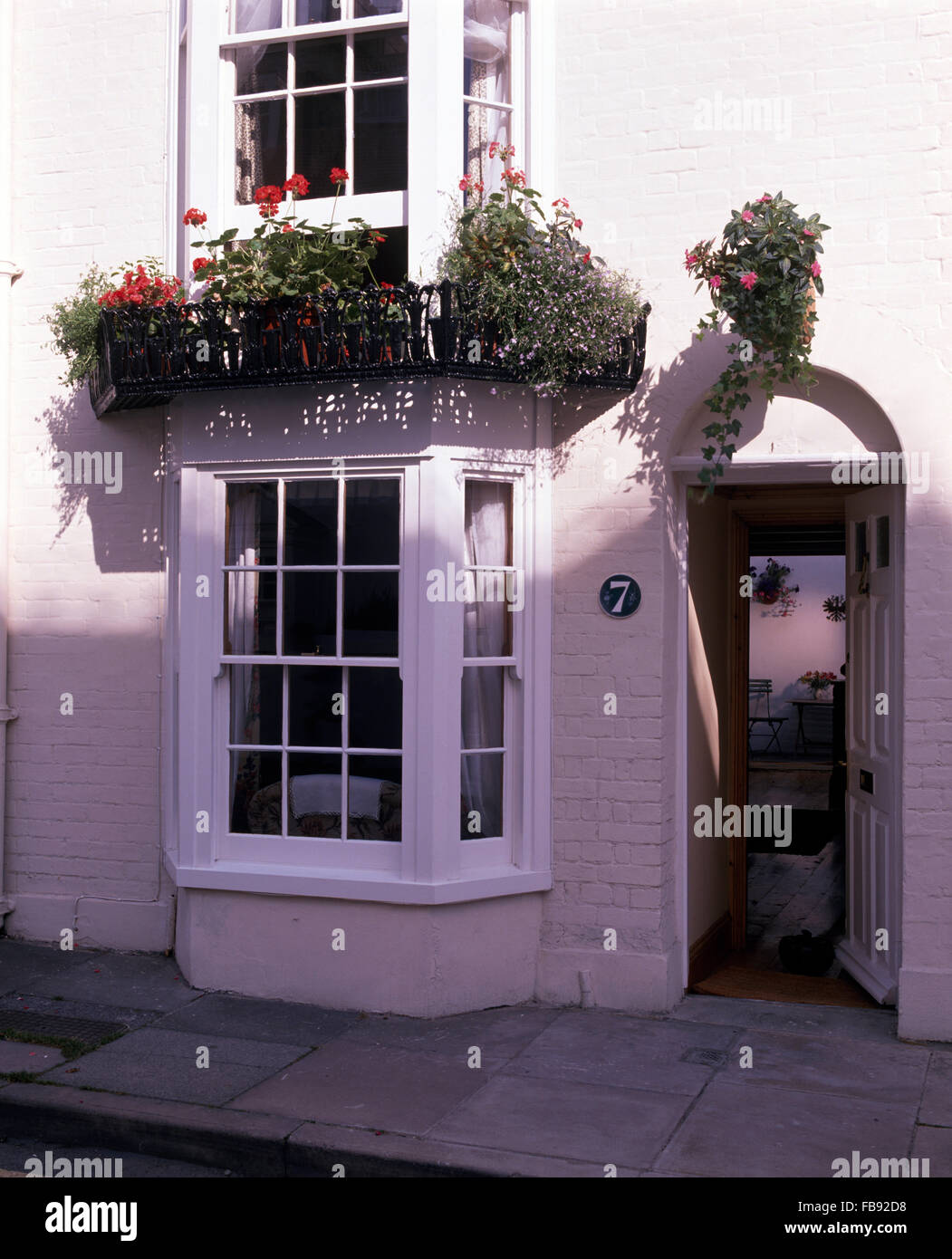 L'extérieur de la ville, laqué blanc cottage avec baies vitrées et une porte avant Banque D'Images