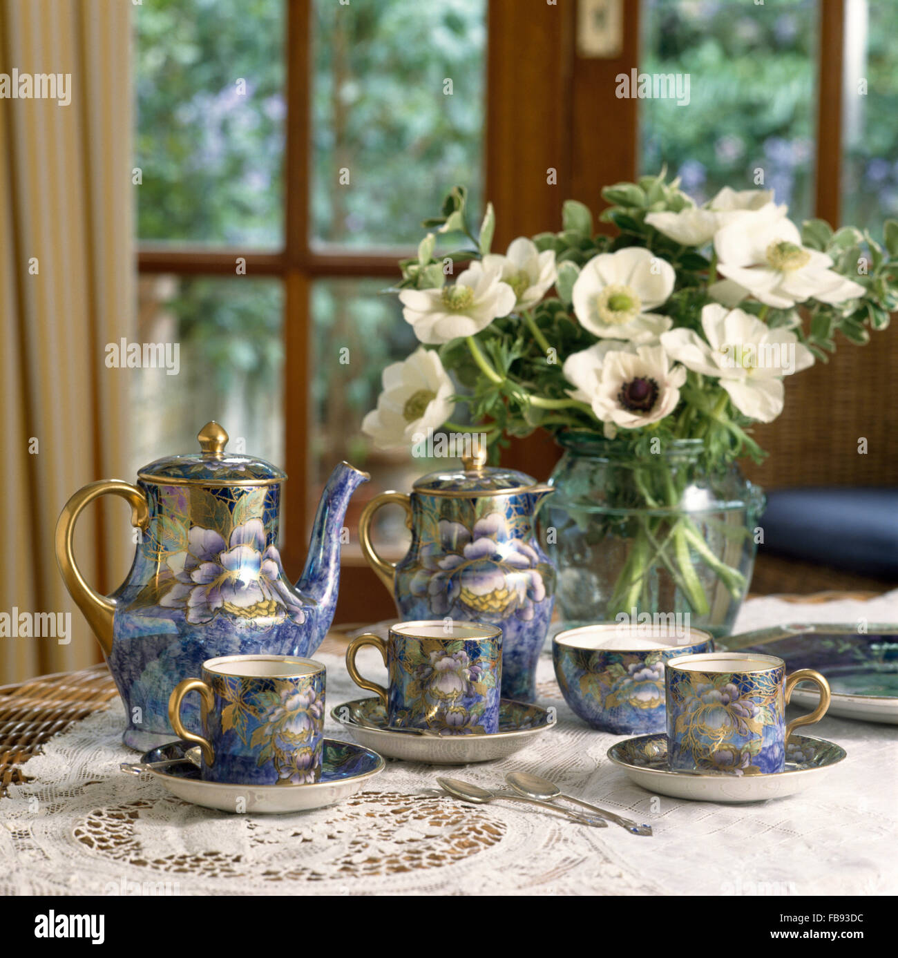 Vase d'anémones blanches et un service à café bleu Le Saëc sur table de salle à manger avec un chiffon blanc en dentelle Banque D'Images Vase d'anémones blanches et un service à café bleu Le Saëc sur table de salle à manger avec un chiffon blanc en dentelle Banque D'Images
