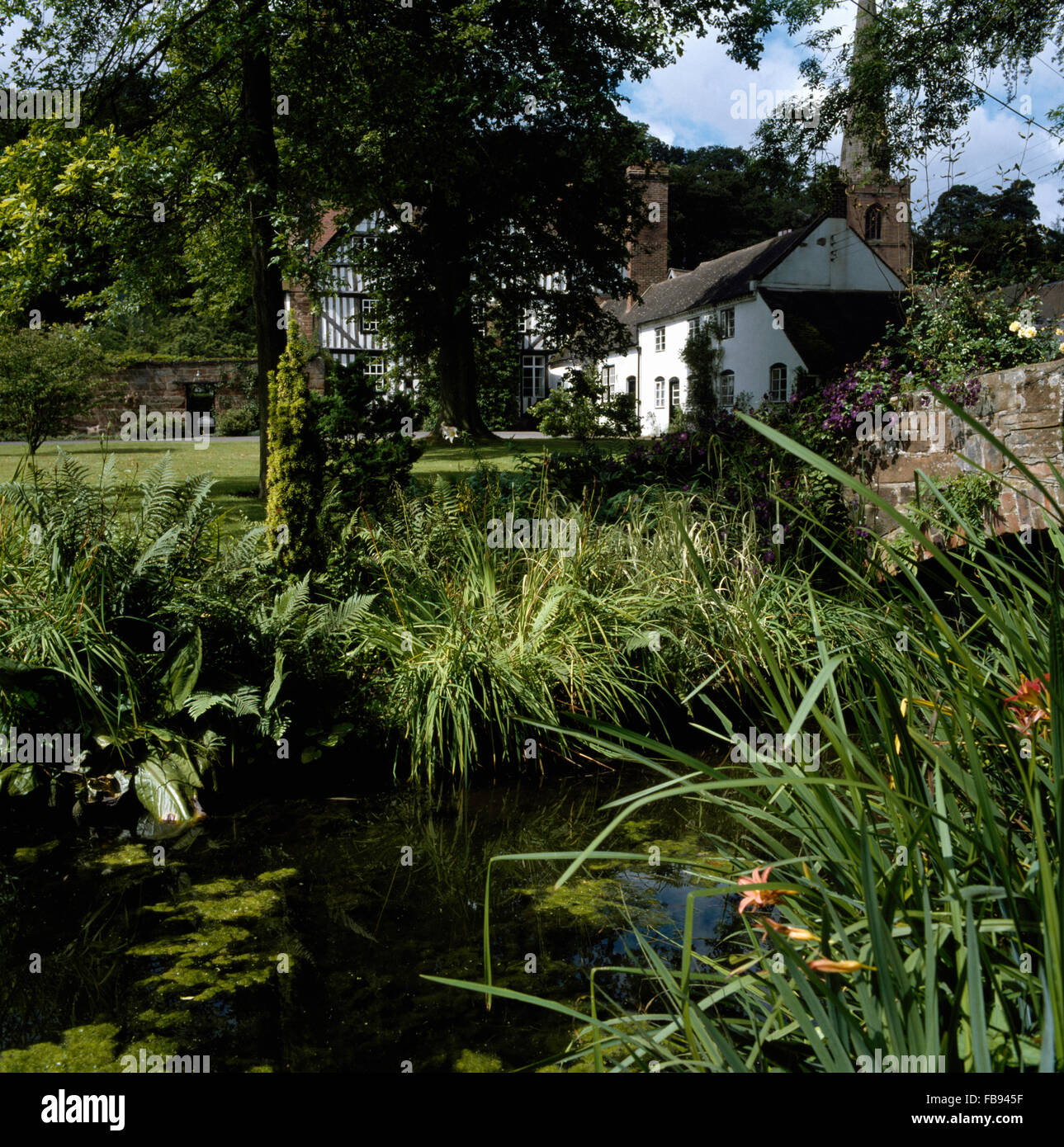 Petit cours d'eau en raison de noir +blanc maison à colombage avec une extension victorien peint en blanc Banque D'Images
