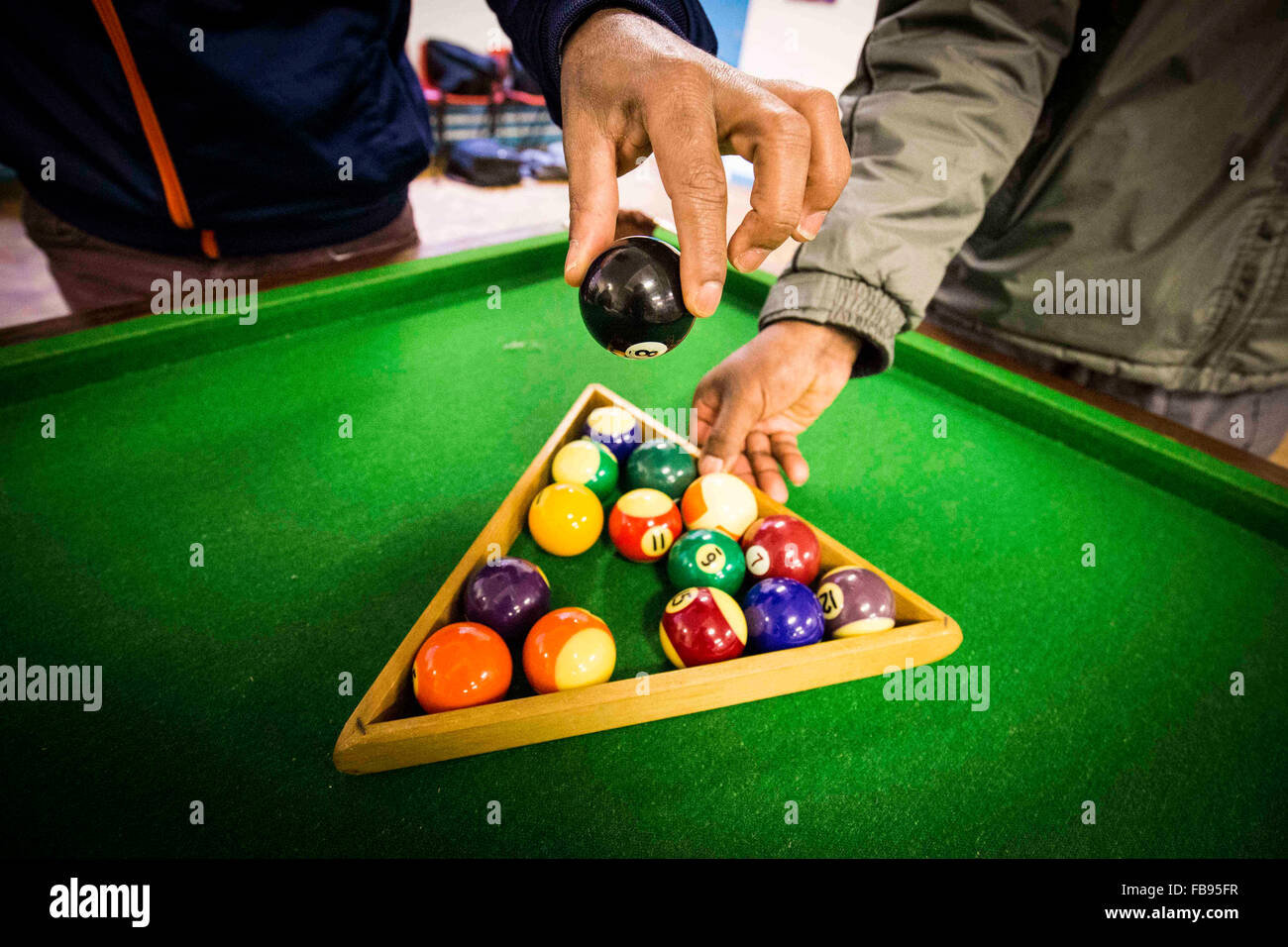 Les jeunes hommes non identifiables, jouer au billard dans un centre communautaire du Royaume-Uni Banque D'Images