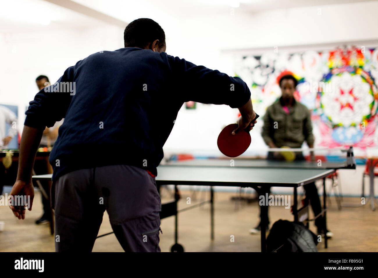 Des jeunes hommes jouer au tennis de table à un centre communautaire au Royaume-Uni Banque D'Images