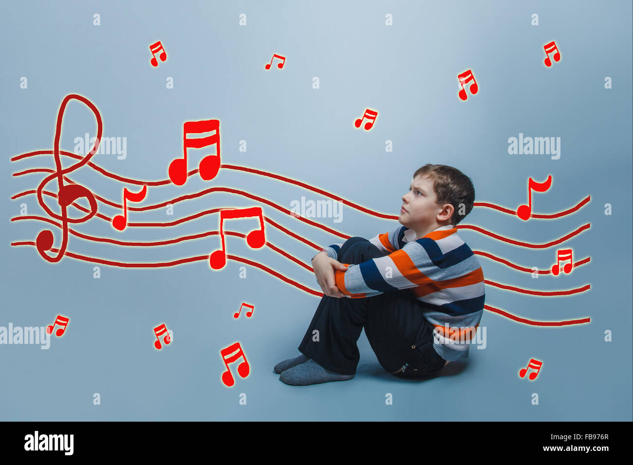 Le garçon en fronçant les adolescents assis l'étreindre les genoux pour empêcher Banque D'Images