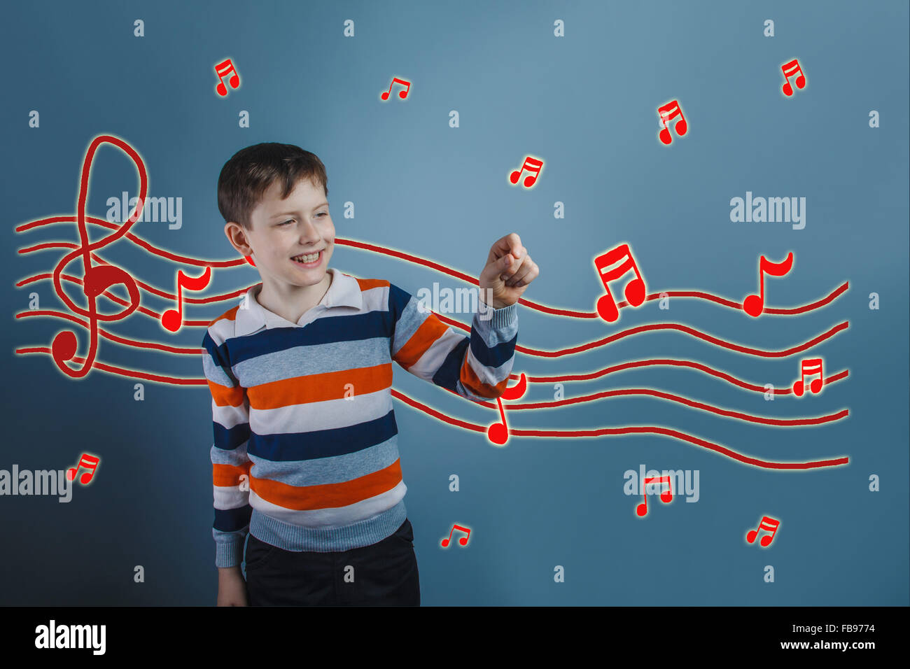 Le rire de l'adolescent garçon détient les notes de musique les doigts pré croquis Banque D'Images