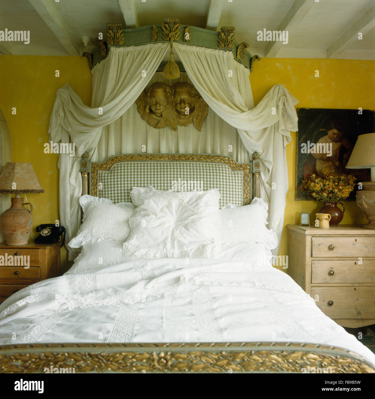 Avec auvent orné de rideaux blancs au-dessus de grand-lit avec draps blancs dans 80 chambres Banque D'Images