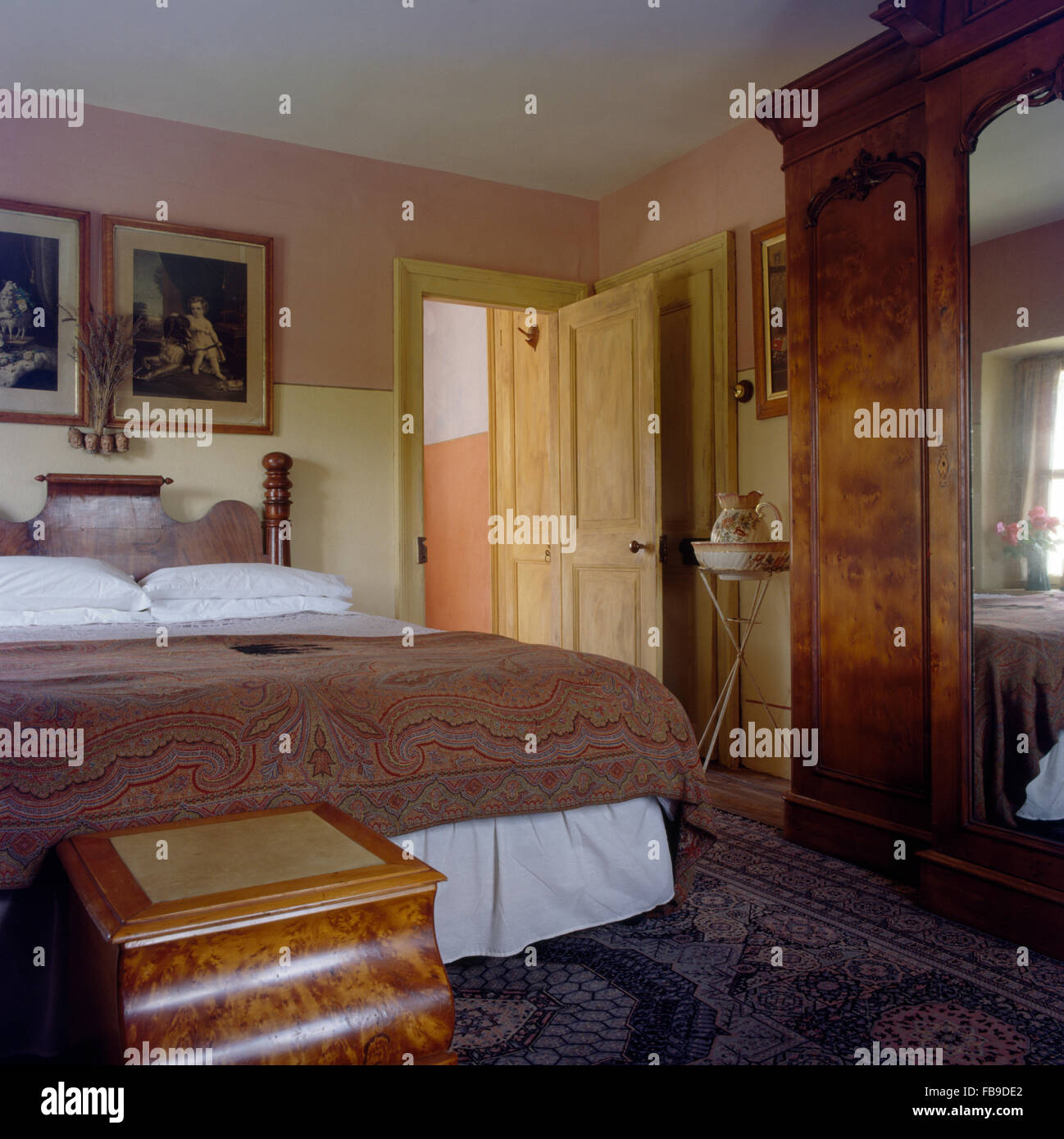 Placage en ronce de noyer la poitrine et armoire dans villa chambres avec  un Paisley jeter sur le lit Photo Stock - Alamy