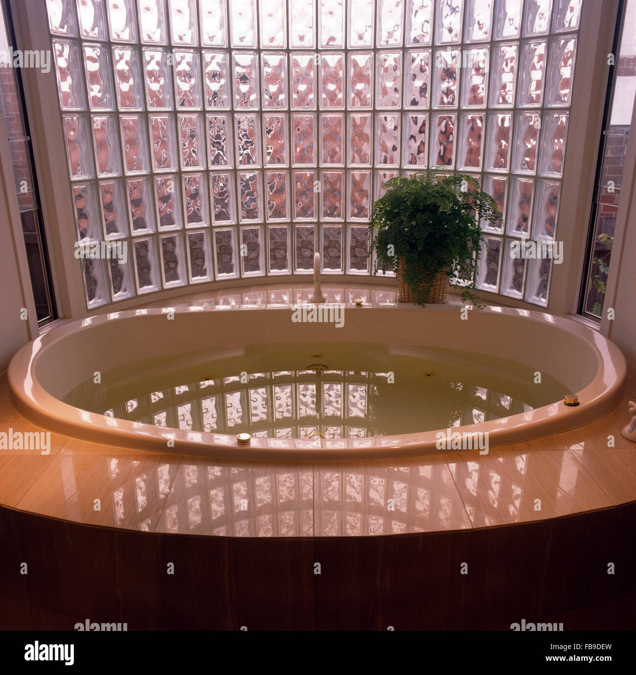Baignoire ovale en face de mur de brique de verre courbé dans une salle de  bains 90 Photo Stock - Alamy