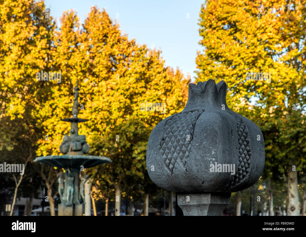 La grenade est le symbole de Grenade en Espagne. Gros plan d'une grenade en pierre avec la fontaine de grenade dans la distance Banque D'Images
