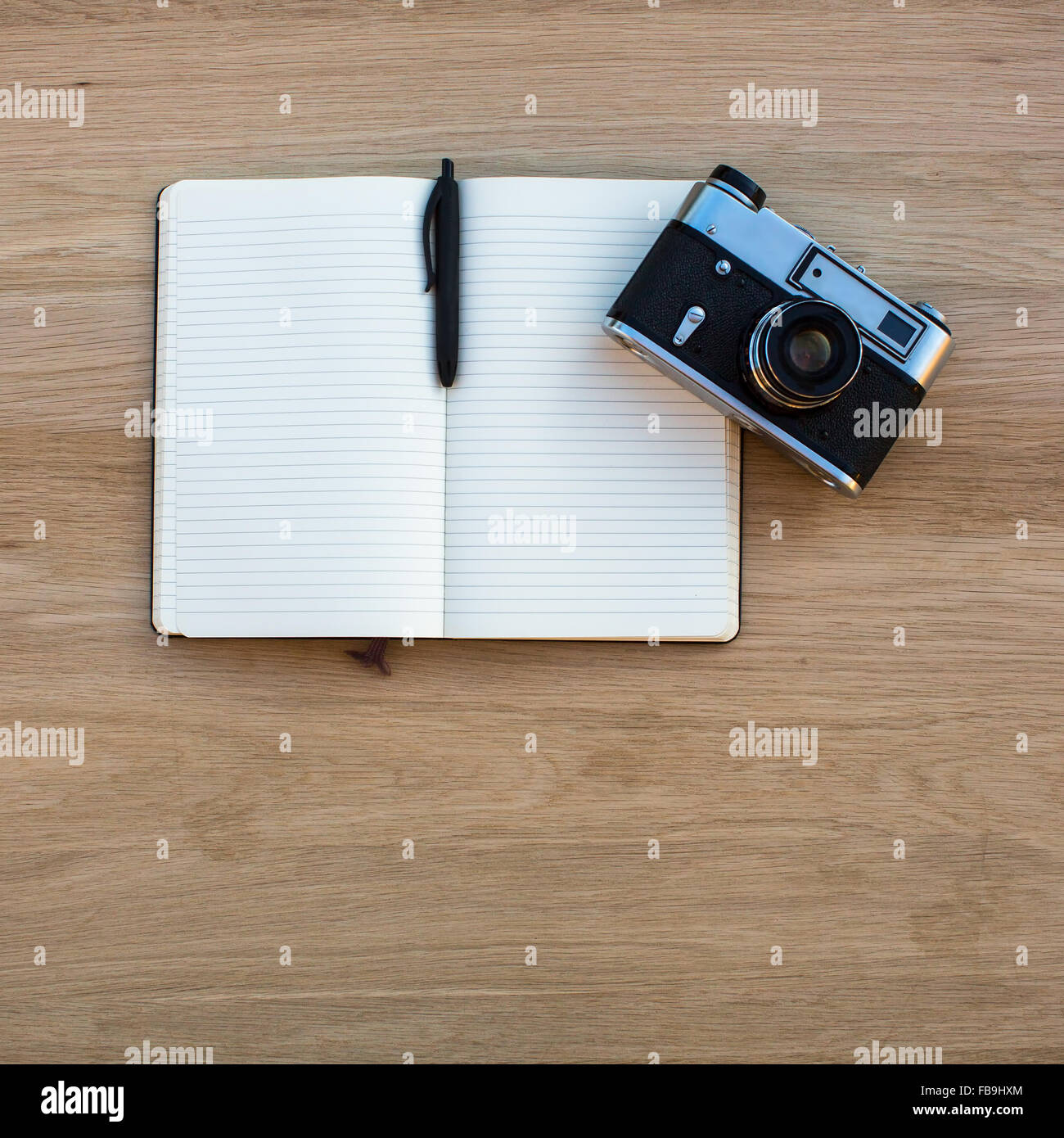 Ouvrir le bloc-notes avec stylo et appareil photo sur la table en bois. Banque D'Images