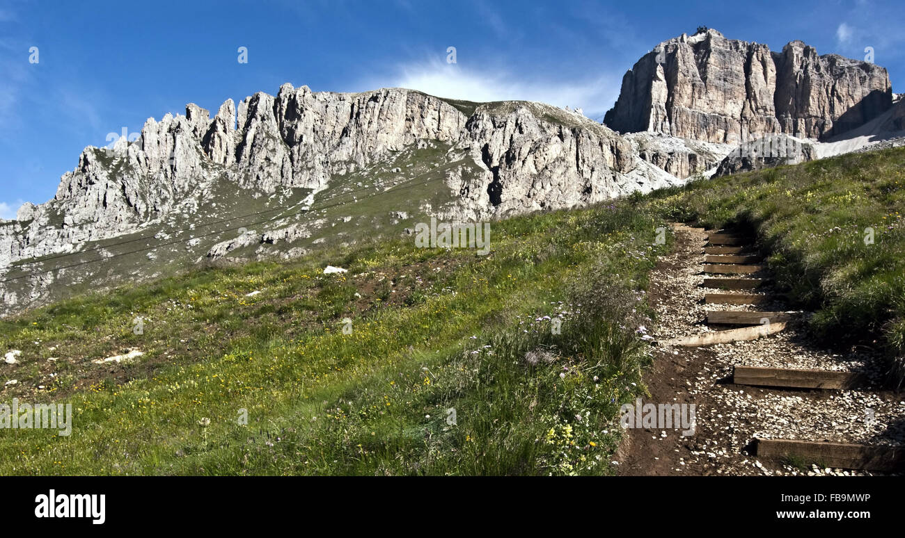 Beau panorama de Piccolo Pordoi et Sass Pordoi avec Prairie et chemin de randonnée ci-dessous avec ciel bleu au cours de randonnées de Passo Banque D'Images