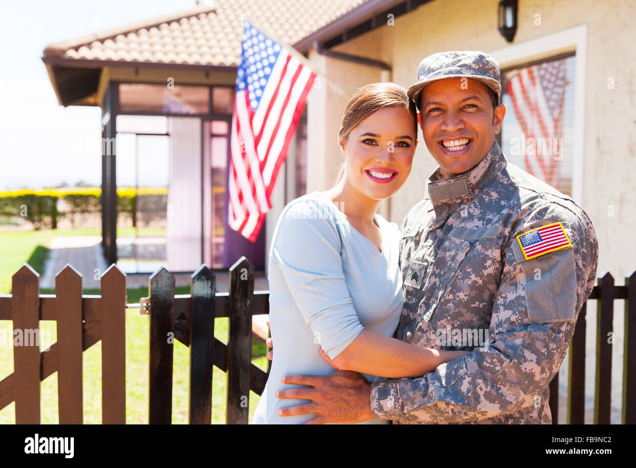 American military couple hugging outside home Banque D'Images