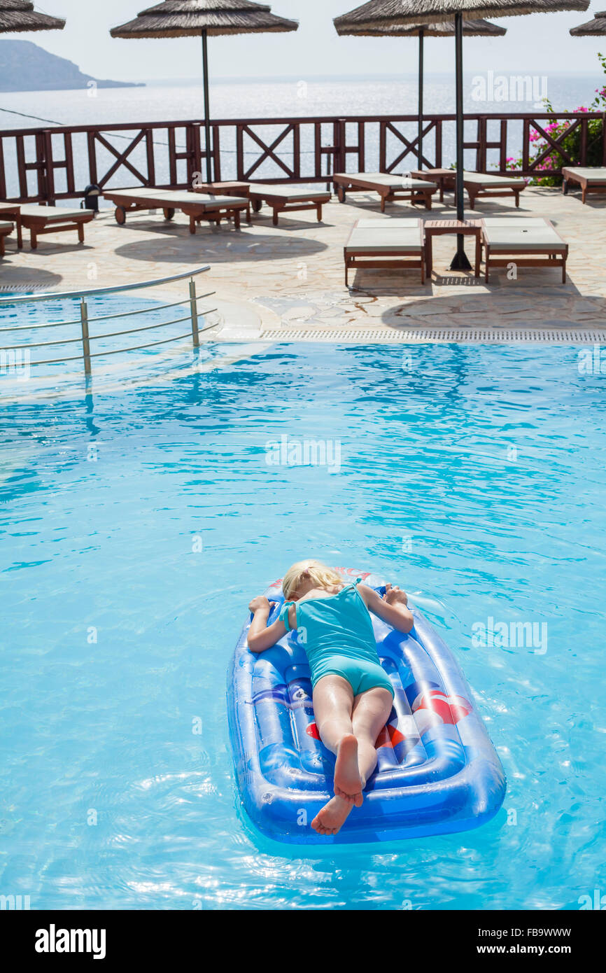 Grèce, Karpathos, Amopi, Girl (6-7) on pool raft Banque D'Images