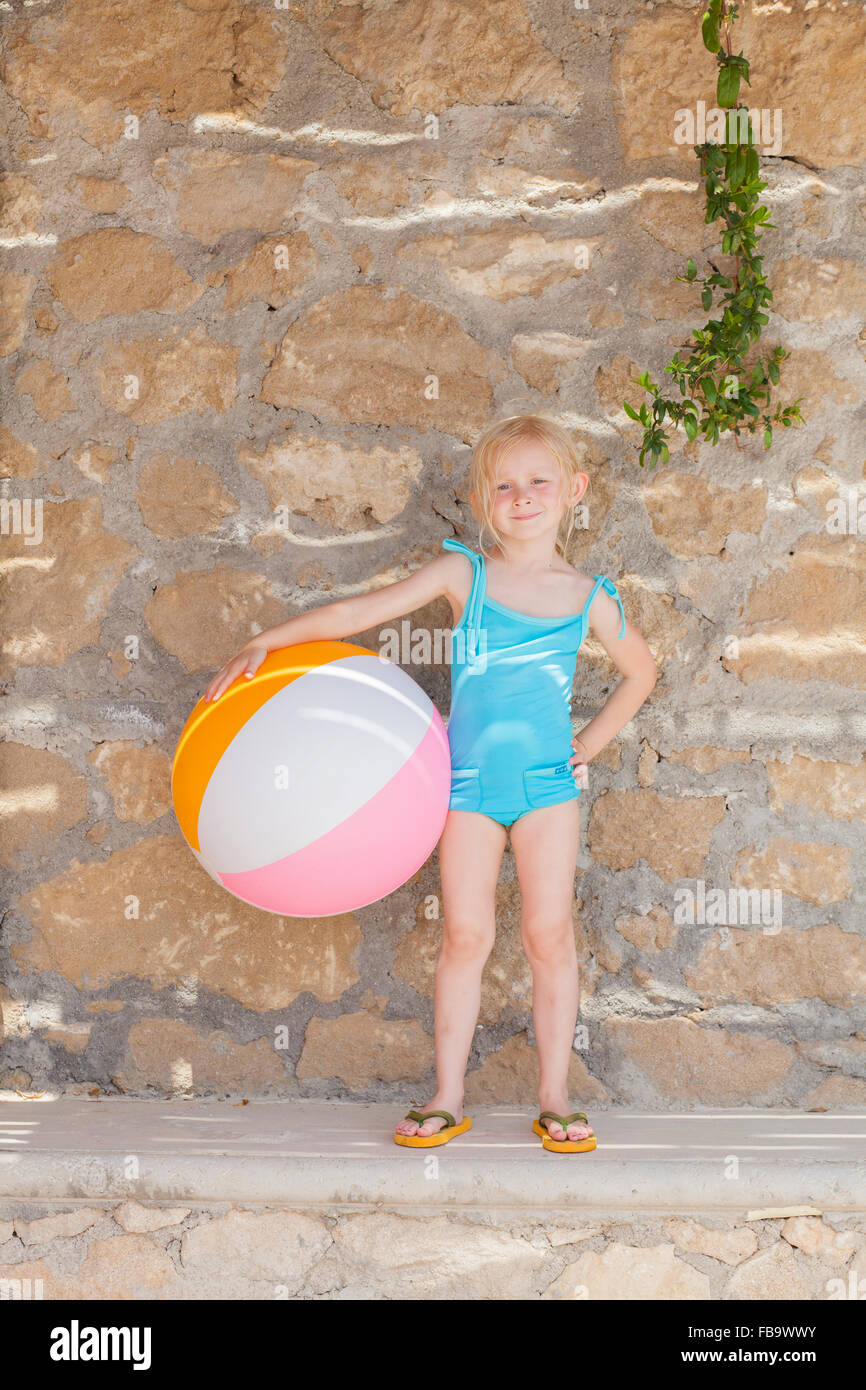 Grèce, Karpathos, Amopi, Girl (6-7) standing with ball Banque D'Images