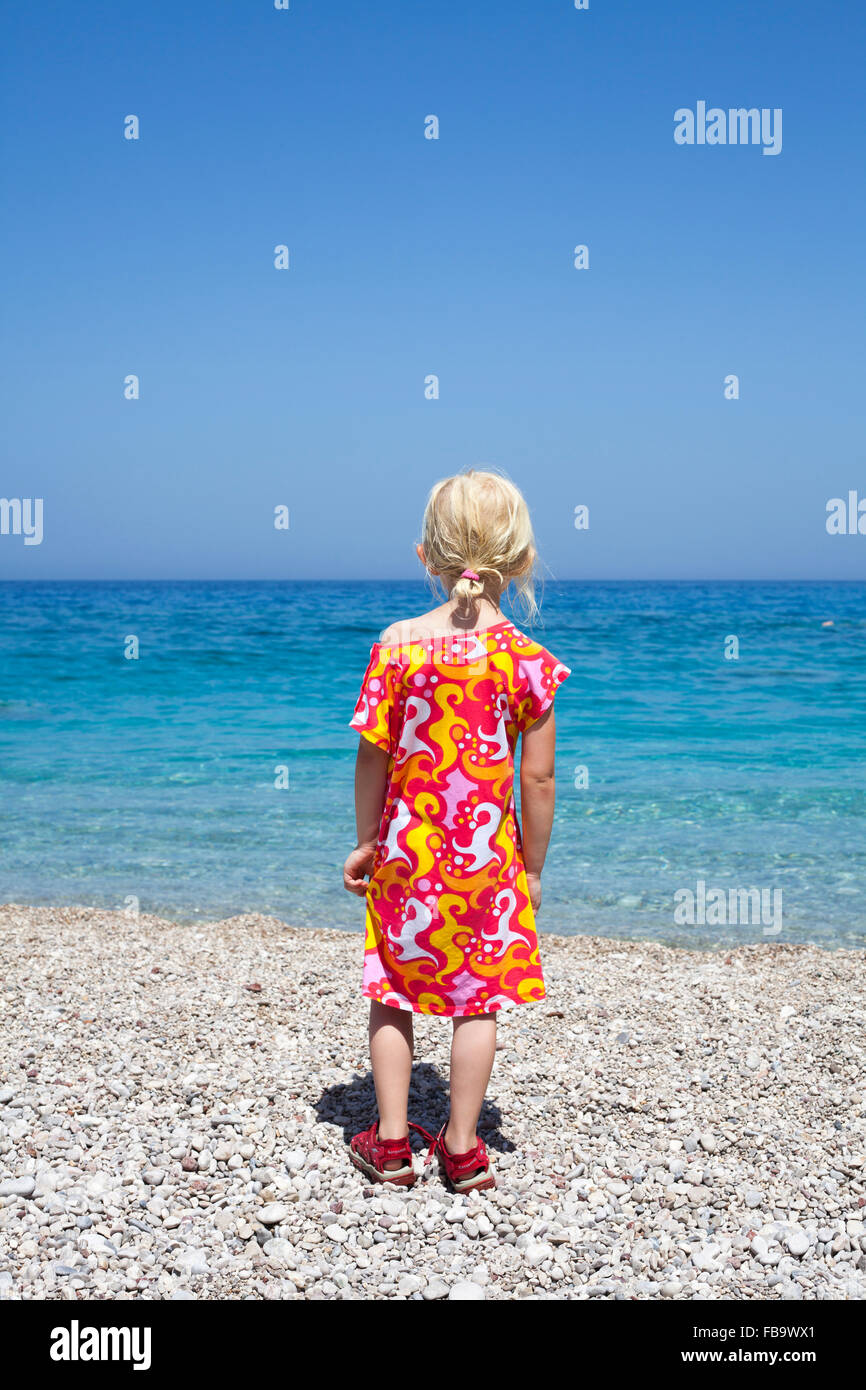 Grèce, Karpathos, Amopi, Girl (6-7) standing on beach Banque D'Images