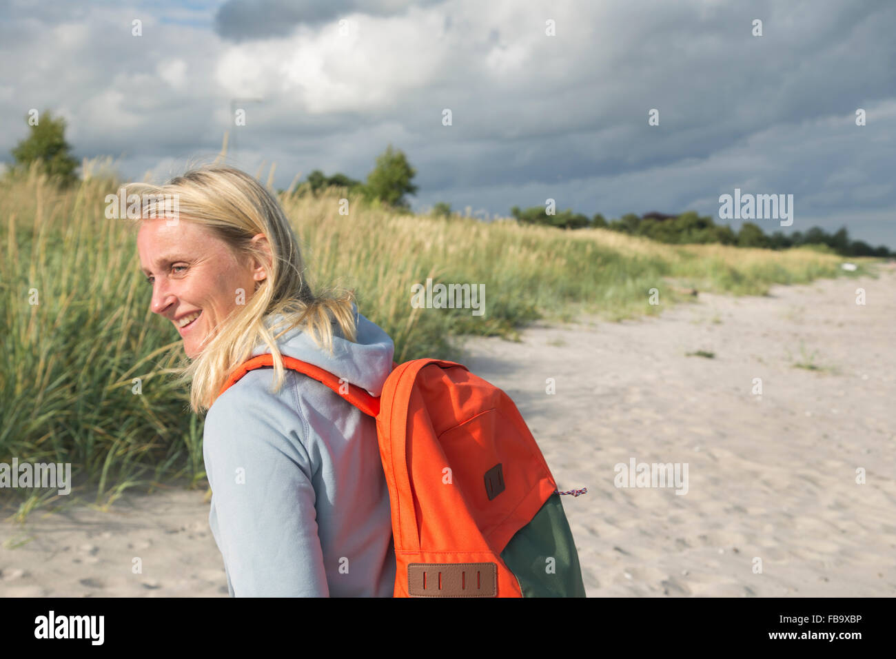 La Suède, Skane, Soderslatt, Smiley, Beddinge Femme avec sac à dos sous ciel nuageux Banque D'Images