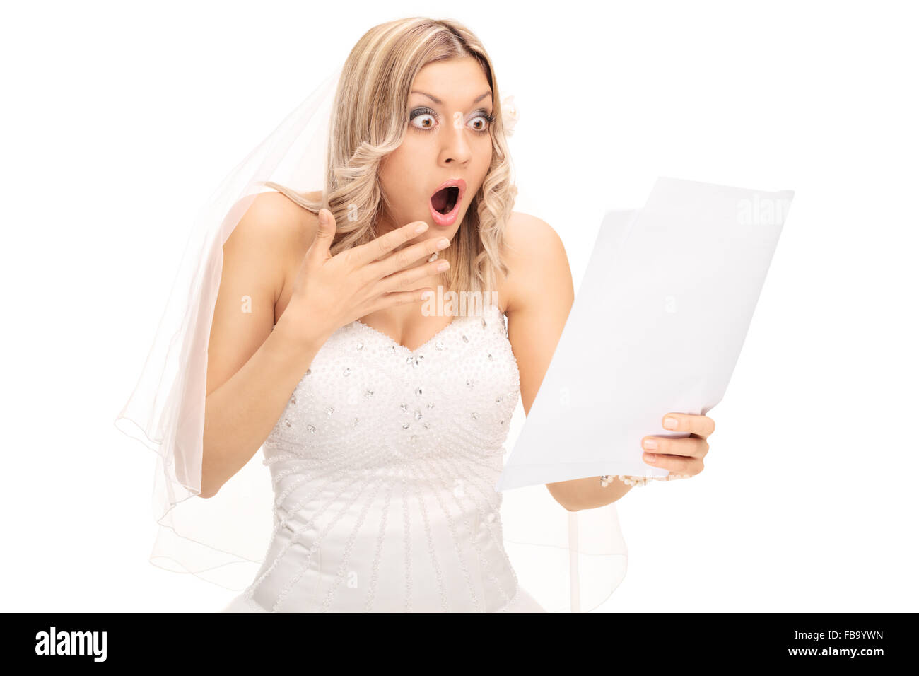 Choqué blonde bride en regardant un morceau de papier dans l'incrédulité isolé sur fond blanc Banque D'Images