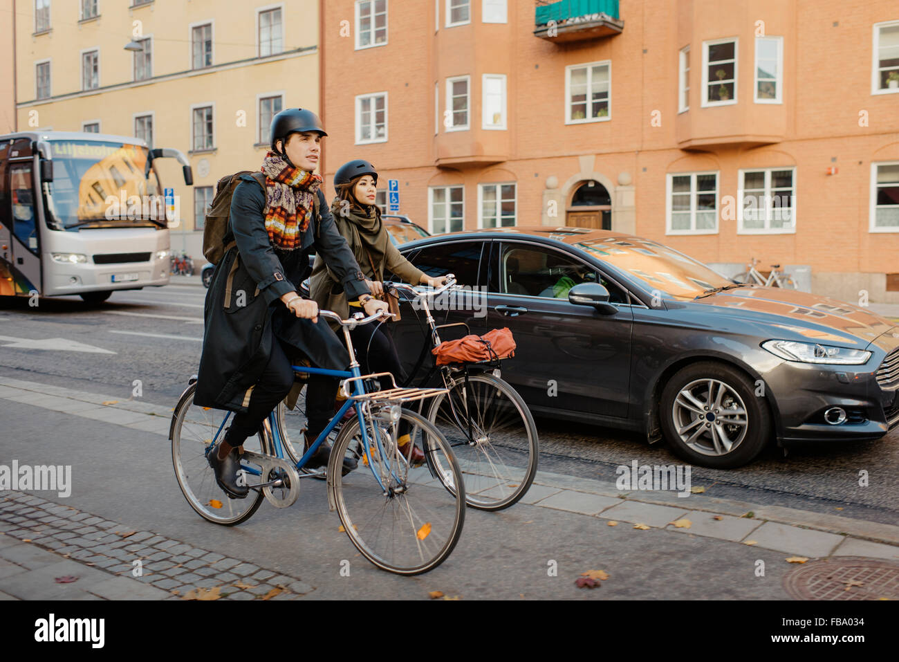 La Suède, l'Uppland, Stockholm, Vasatan, Sankt Eriksgatan, homme et femme, à vélo on city street Banque D'Images