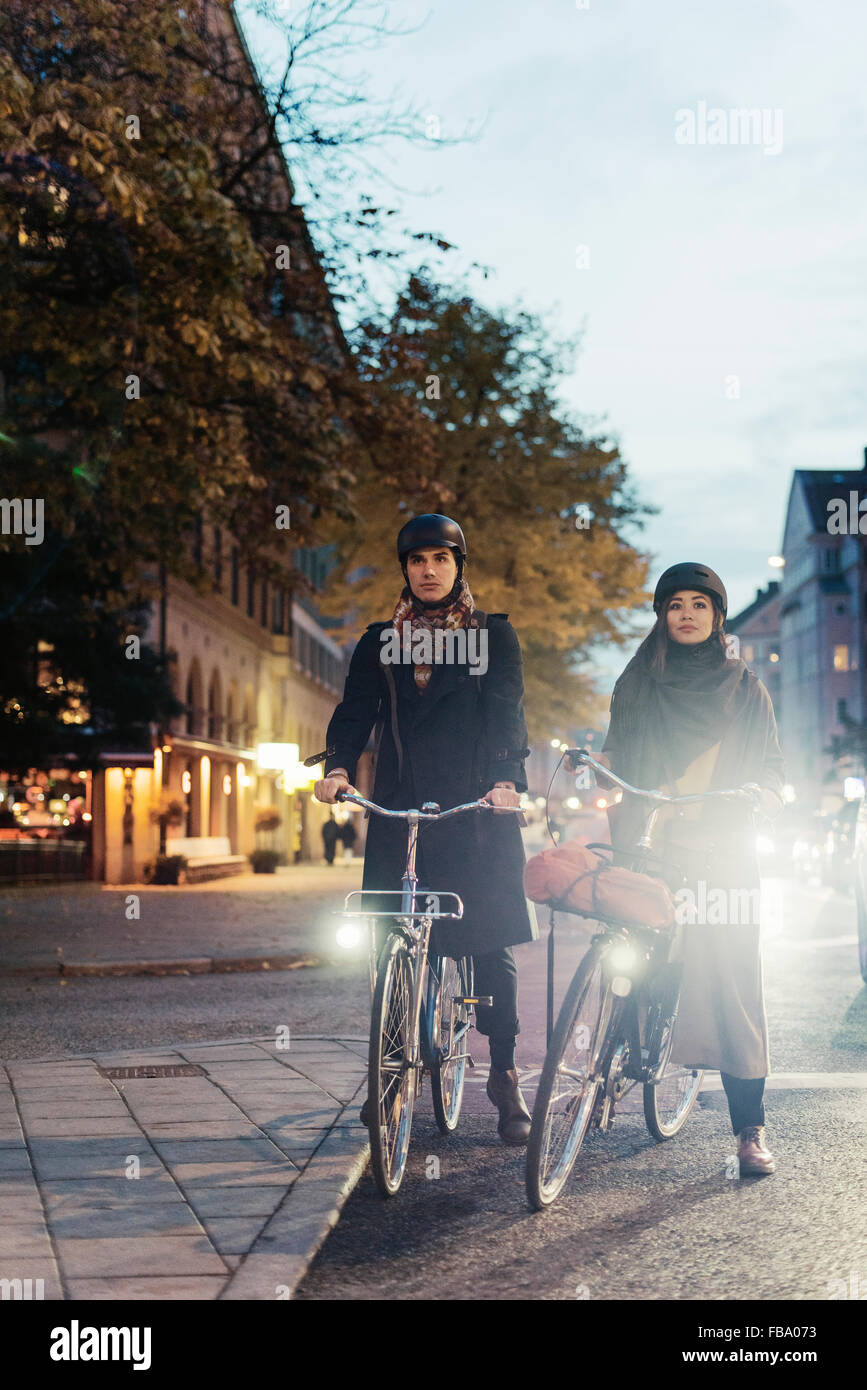 La Suède, l'Uppland, Stockholm, Vasatan, Sankt Eriksgatan, homme et femme, à vélo on city street Banque D'Images