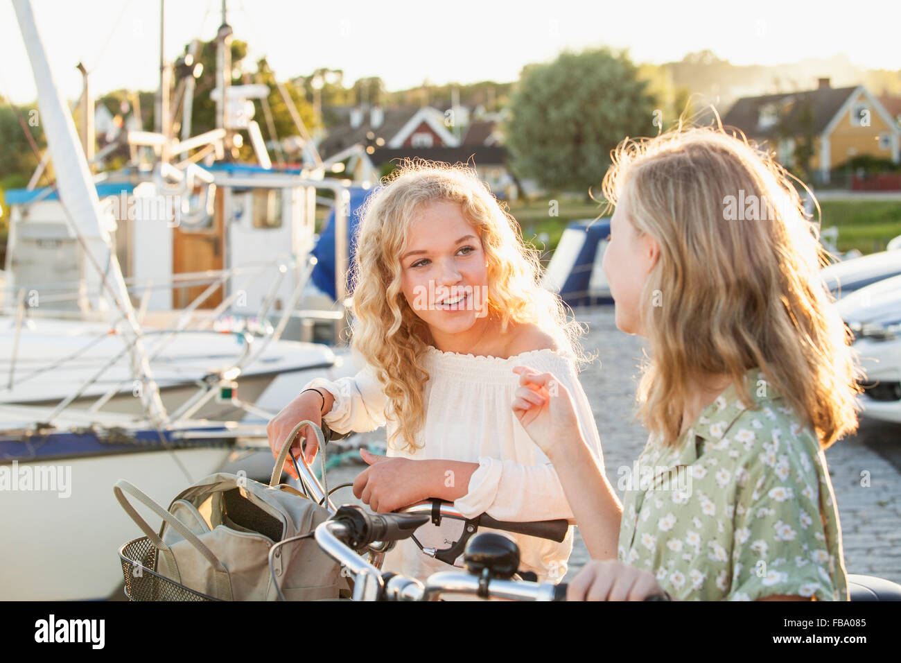 La Suède, Blekinge, Hallevik, deux adolescentes(14-15, 16-17) avec des vélos à parler à Marina Bay Banque D'Images