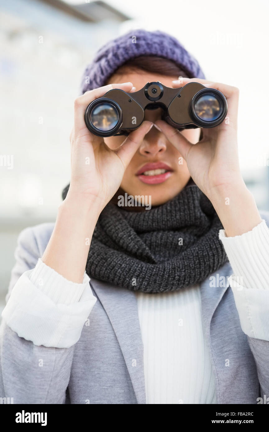 Femme avec des vêtements d'hiver à la recherche de jumelles en Banque D'Images