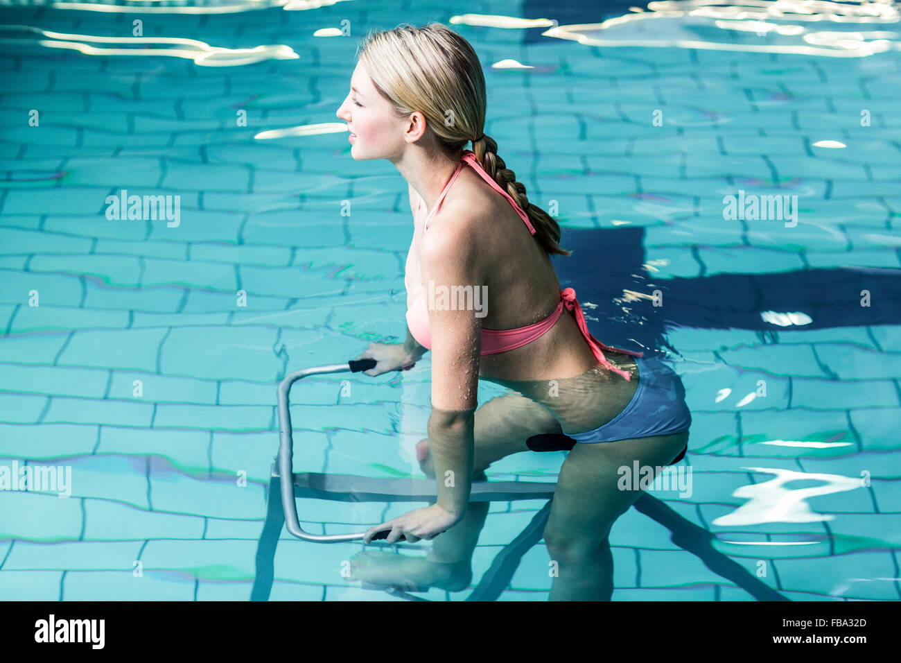 Fit woman cycling dans la piscine Banque D'Images
