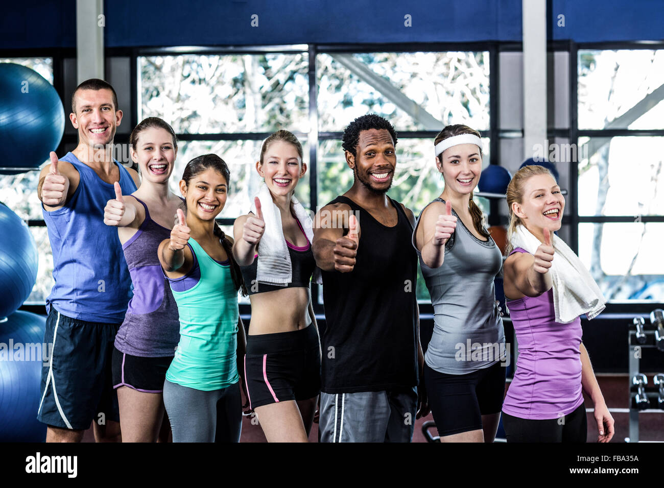 Smiling fitness class posing together with Thumbs up Banque D'Images