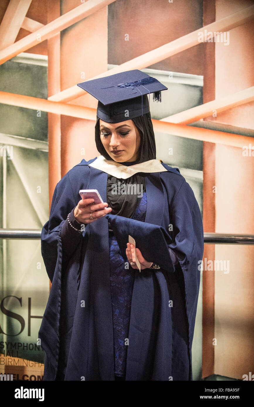 Les jeunes femmes musulmanes graduand avec smart phone, cérémonie de remise de diplômes Banque D'Images