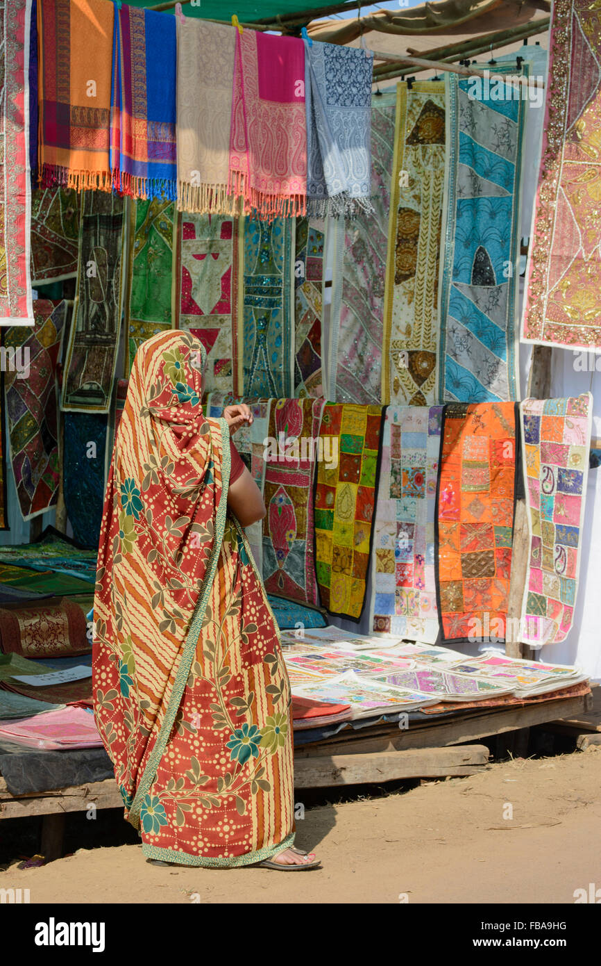 Femme indienne vendant des tissus colorés à l'Mercredi marché aux puces d'Anjuna, plage dans le Nord de Goa, Inde Banque D'Images