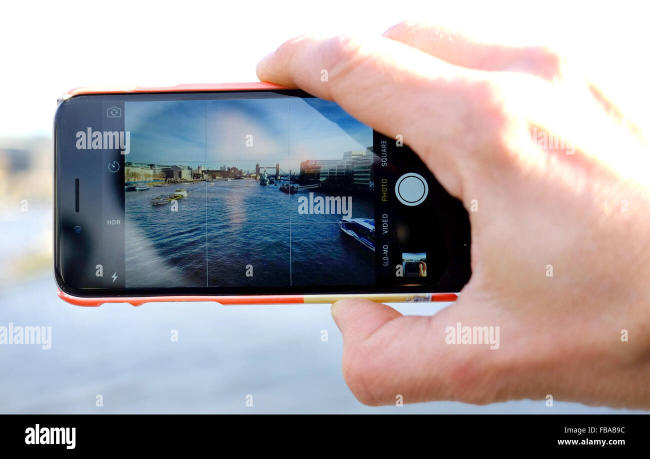 Prendre une photo de Londres sur un smartphone, le Tower Bridge, le HMS Belfast, tamise sur un iPhone 6/6S Banque D'Images