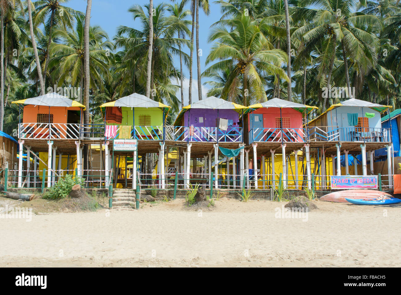 Cabines colorées parmi les palmiers sur la plage de Palolem, Sud de Goa, Inde Banque D'Images