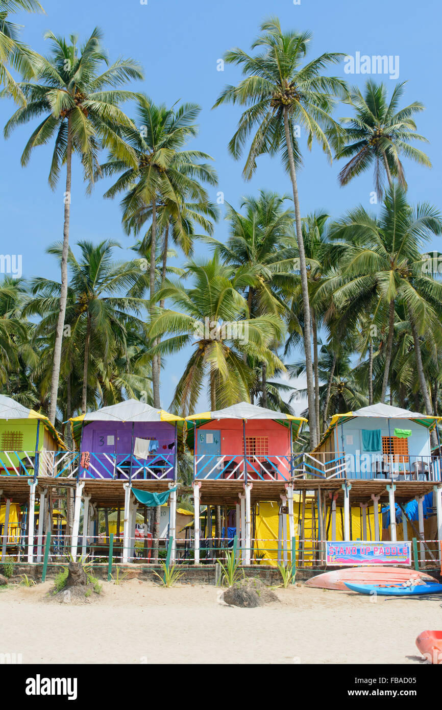 Cabines colorées parmi les palmiers sur la plage de Palolem, Sud de Goa, Inde Banque D'Images