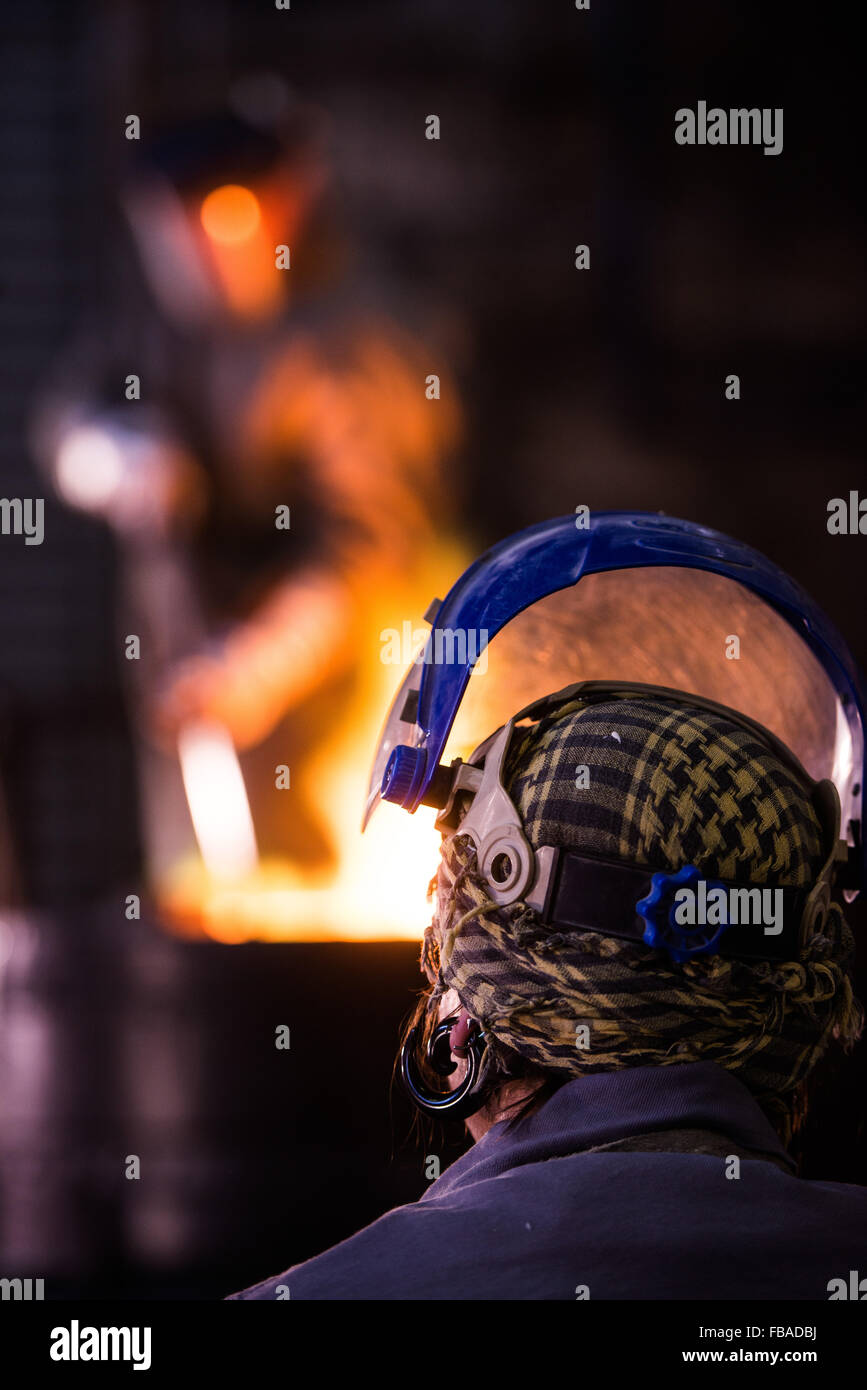 Travailleur de l'acier dans des vêtements de ratisser dans un four de fonderie industrielle Banque D'Images