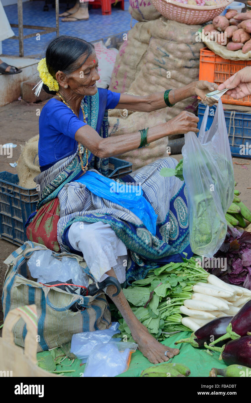 Femme indienne vidéo à la demande au paiement à la vente de feuilles à Mapusa, dans le quartier animé de vendredi, marché, Nord de Goa Anjuna, Inde Banque D'Images