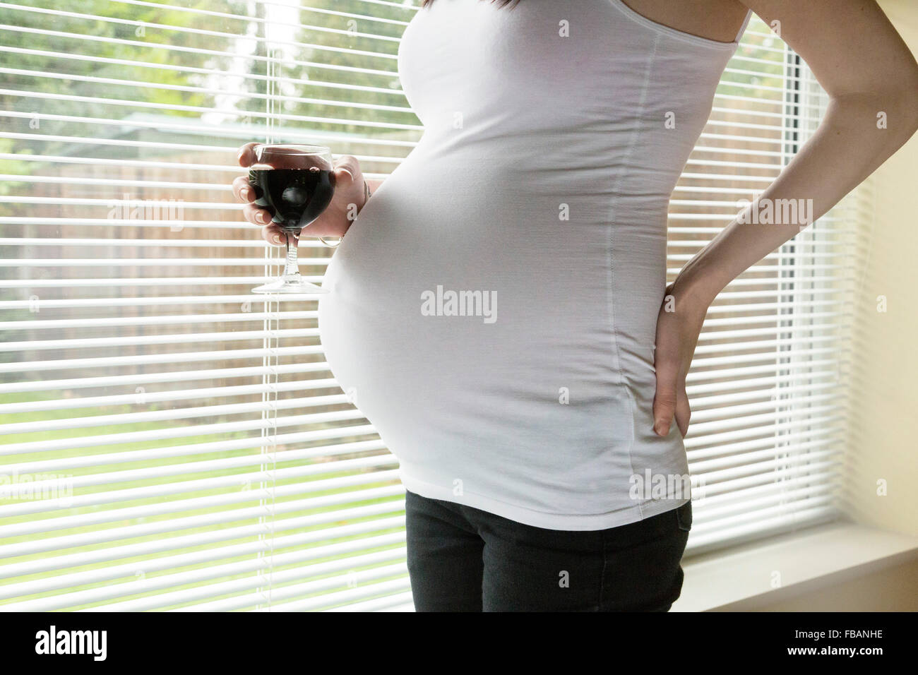 Femme enceinte de boire de l'alcool / vin rouge Banque D'Images