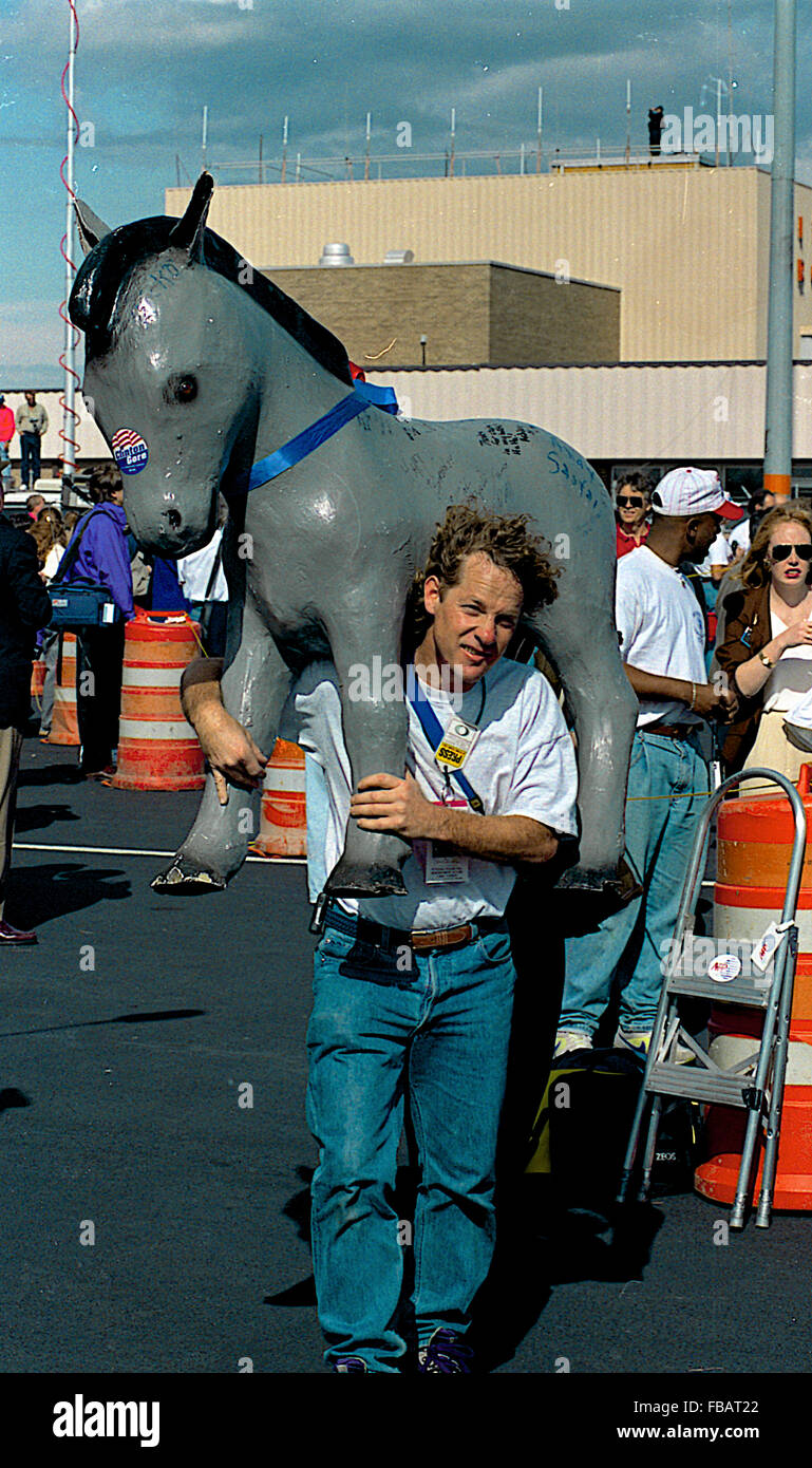 Little Rock, Arkansas, USA, 3 novembre 1992, un membre de la presse de voyage qui avait été couvrant le Gouverneur au cours de la campagne s'éloigne de l'avion avec la mascotte âne en papier mâché. Credit : Mark Reinstein Banque D'Images