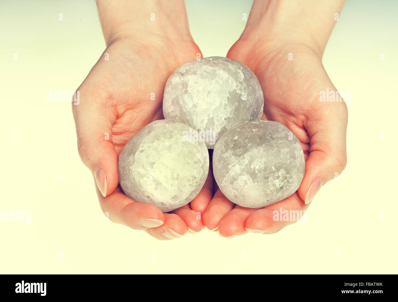 Les mains tenant l'halite ronde cristaux de sel de roche pour la médecine alternative Banque D'Images