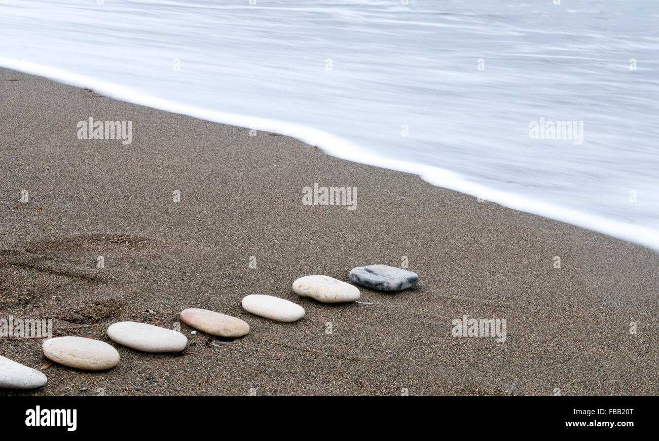 Plage lisse dans une rangée de pierres et mer vague. Une longue exposition photo. Banque D'Images